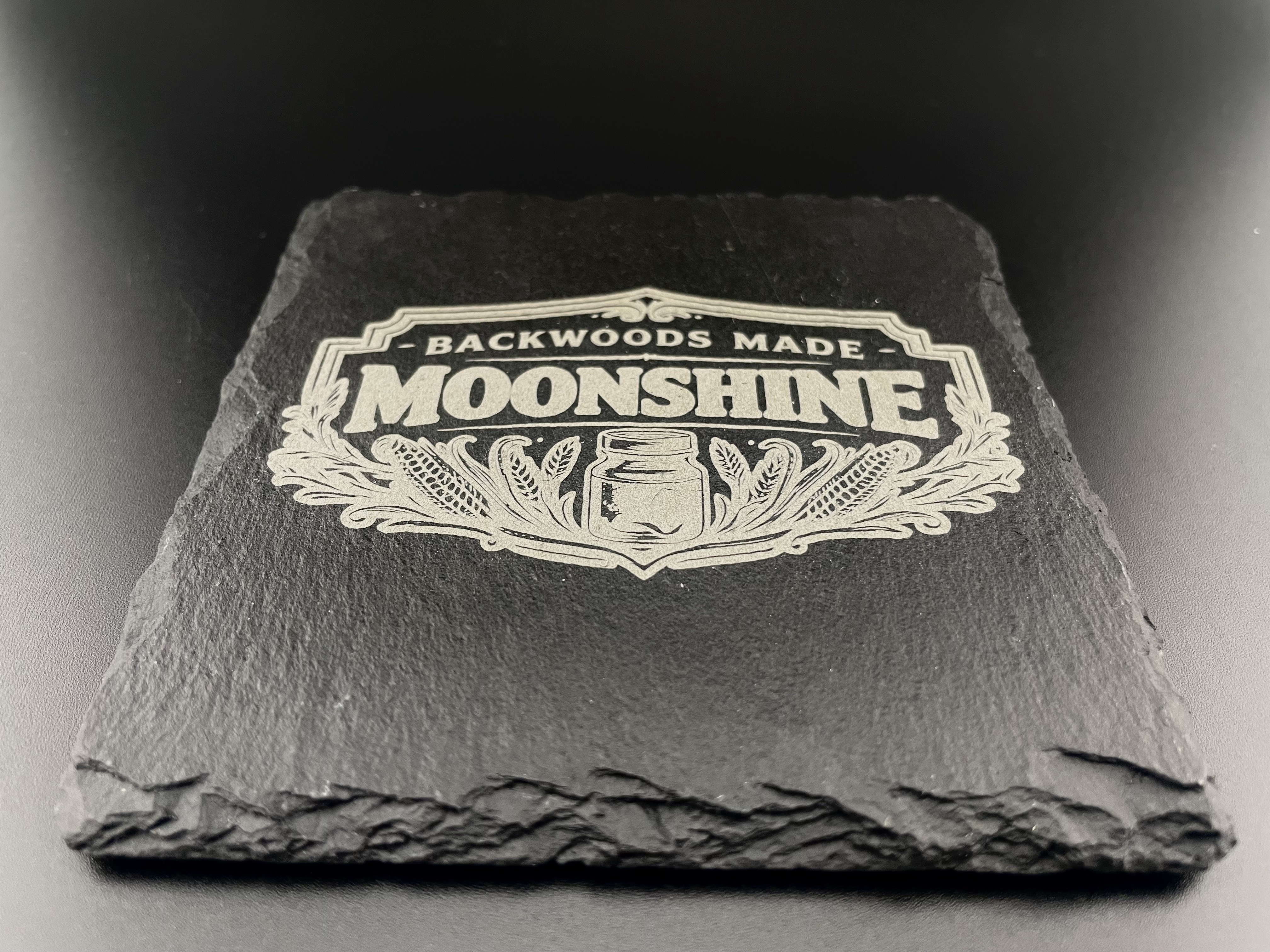 Backwoods Made Moonshine slate coaster, close-up laser engraving